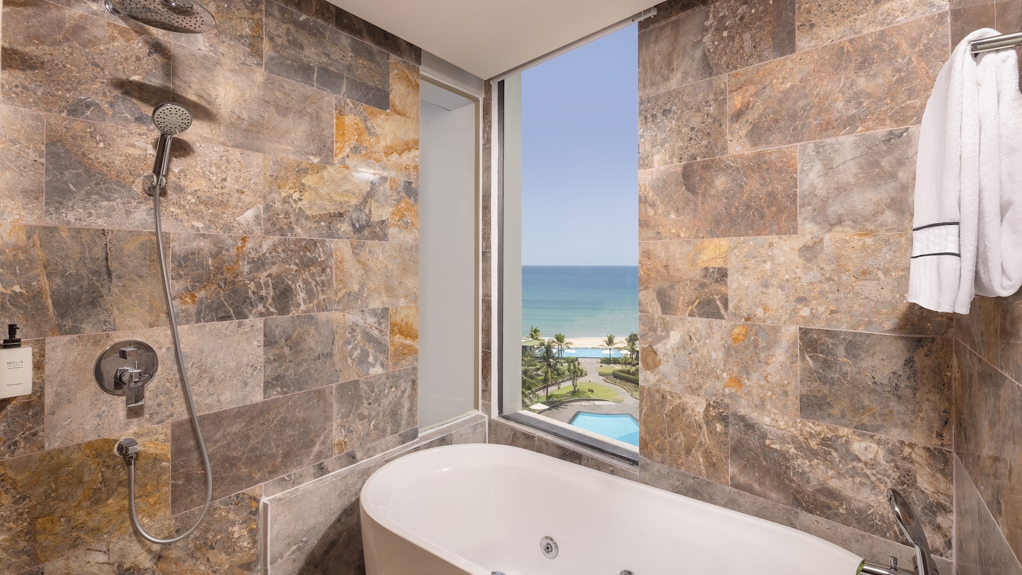 a bathroom with a bathtub and a view of the ocean