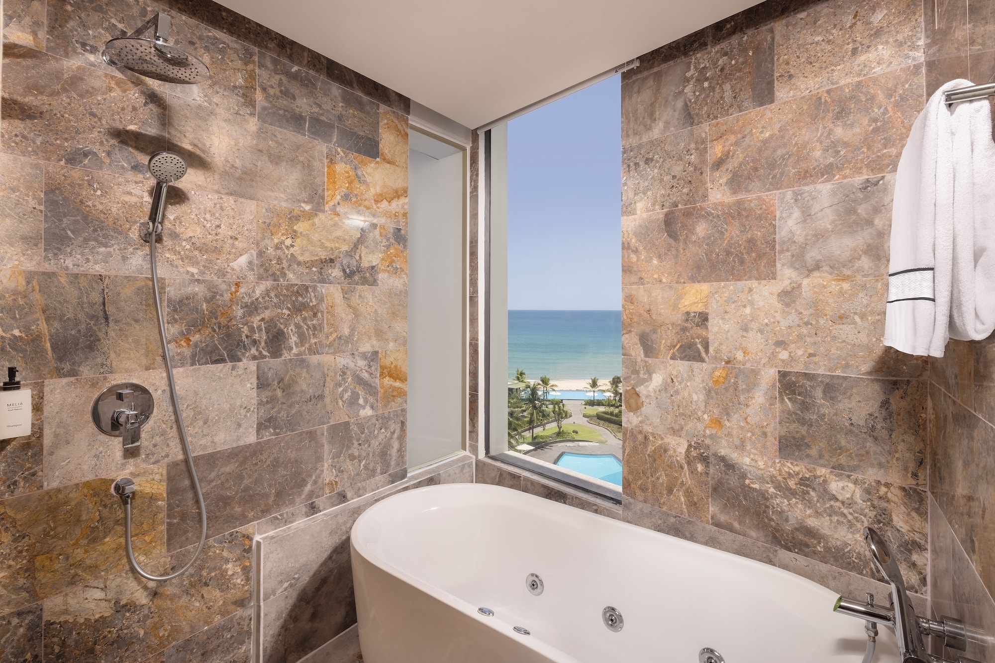 a bathroom with a bathtub and a view of the ocean