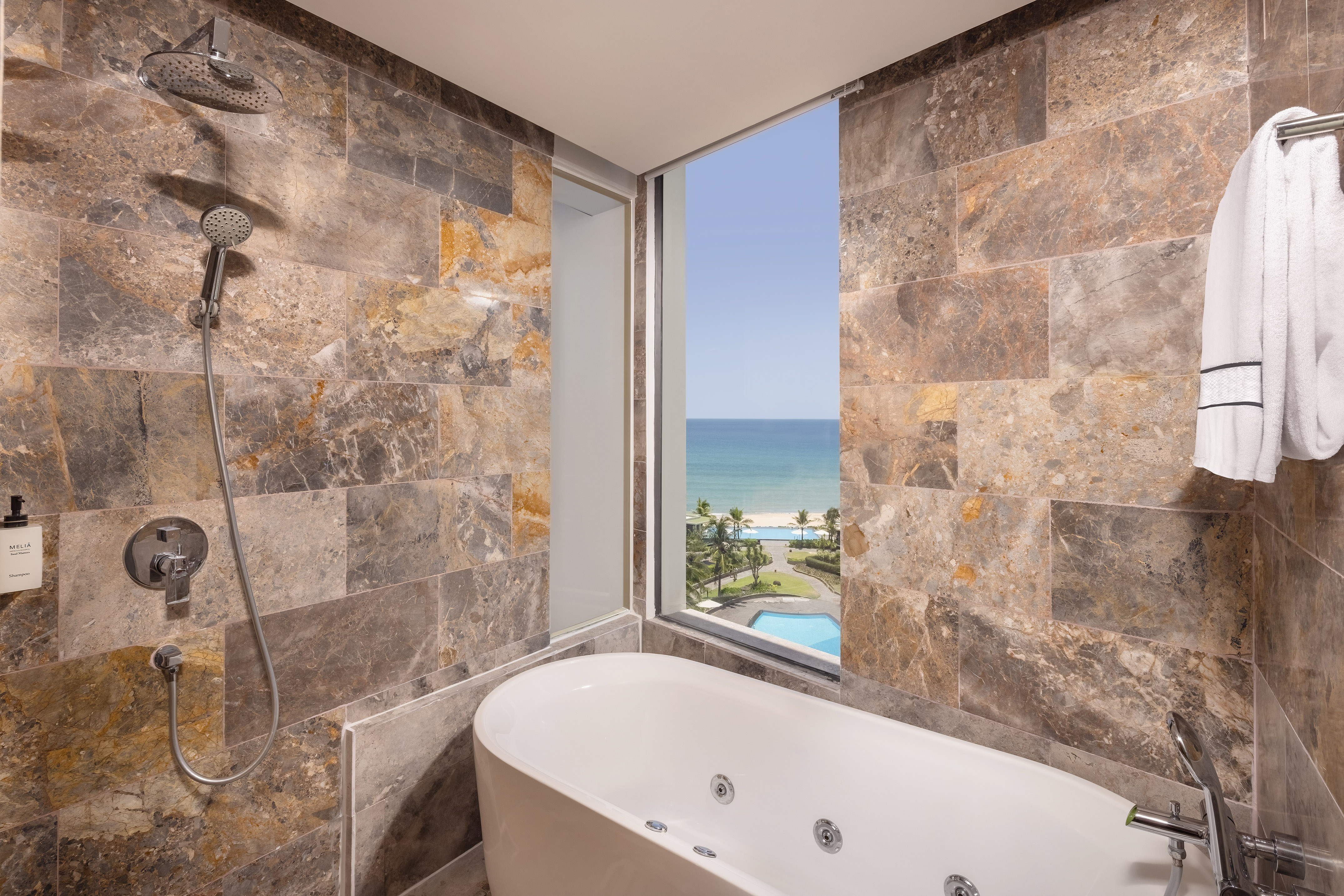 a bathroom with a bathtub and a view of the ocean