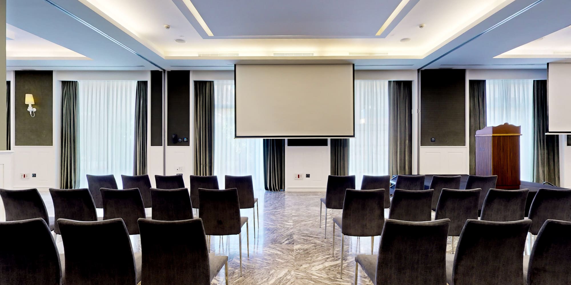 a room with chairs and a projector screen
