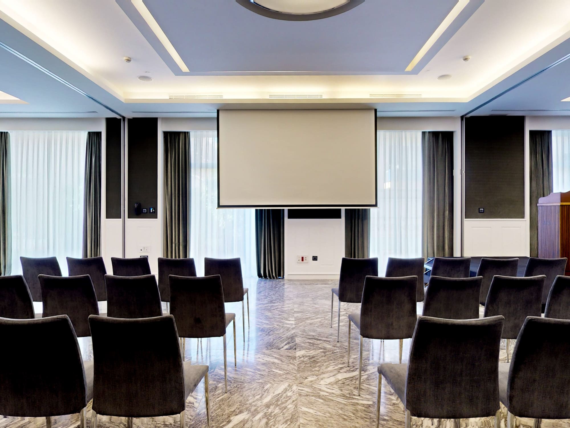 a room with chairs and a projector screen