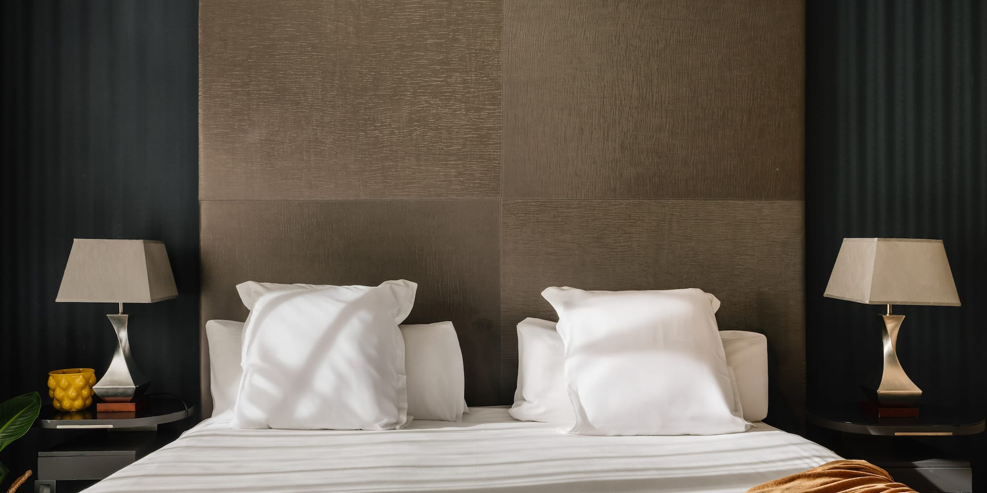 a bed with white sheets and pillows
