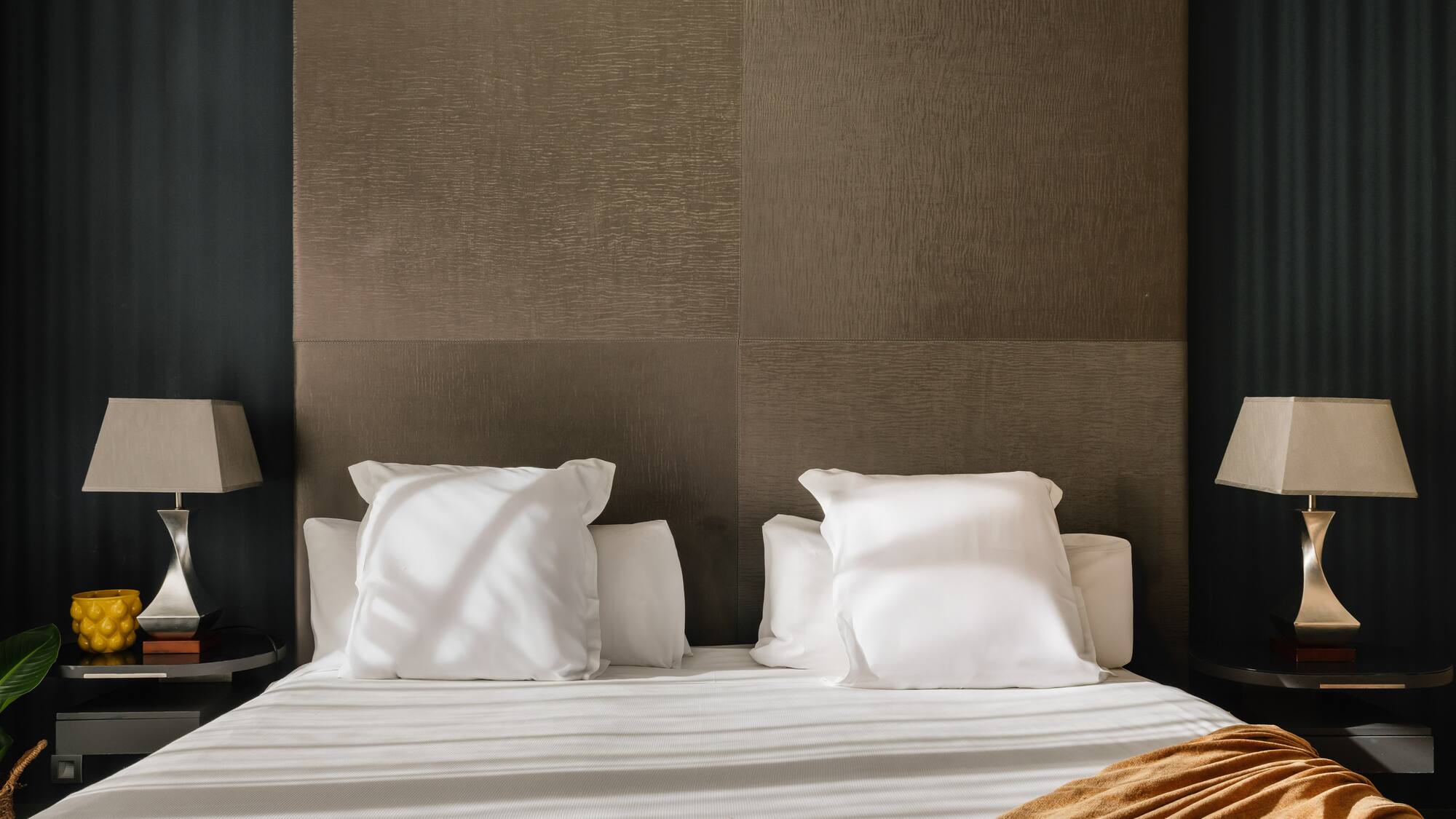 a bed with white sheets and pillows