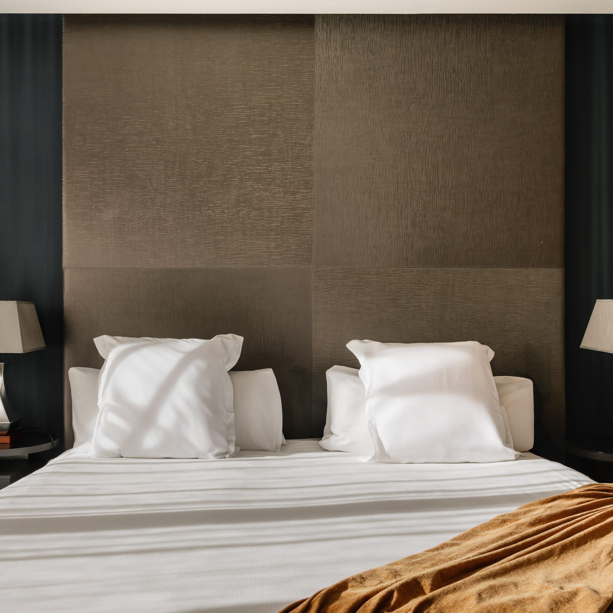 a bed with white sheets and pillows