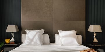 a bed with white sheets and pillows