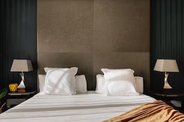 a bed with white sheets and pillows