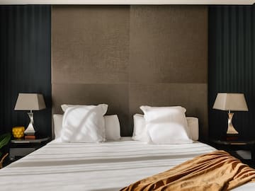 a bed with white sheets and pillows