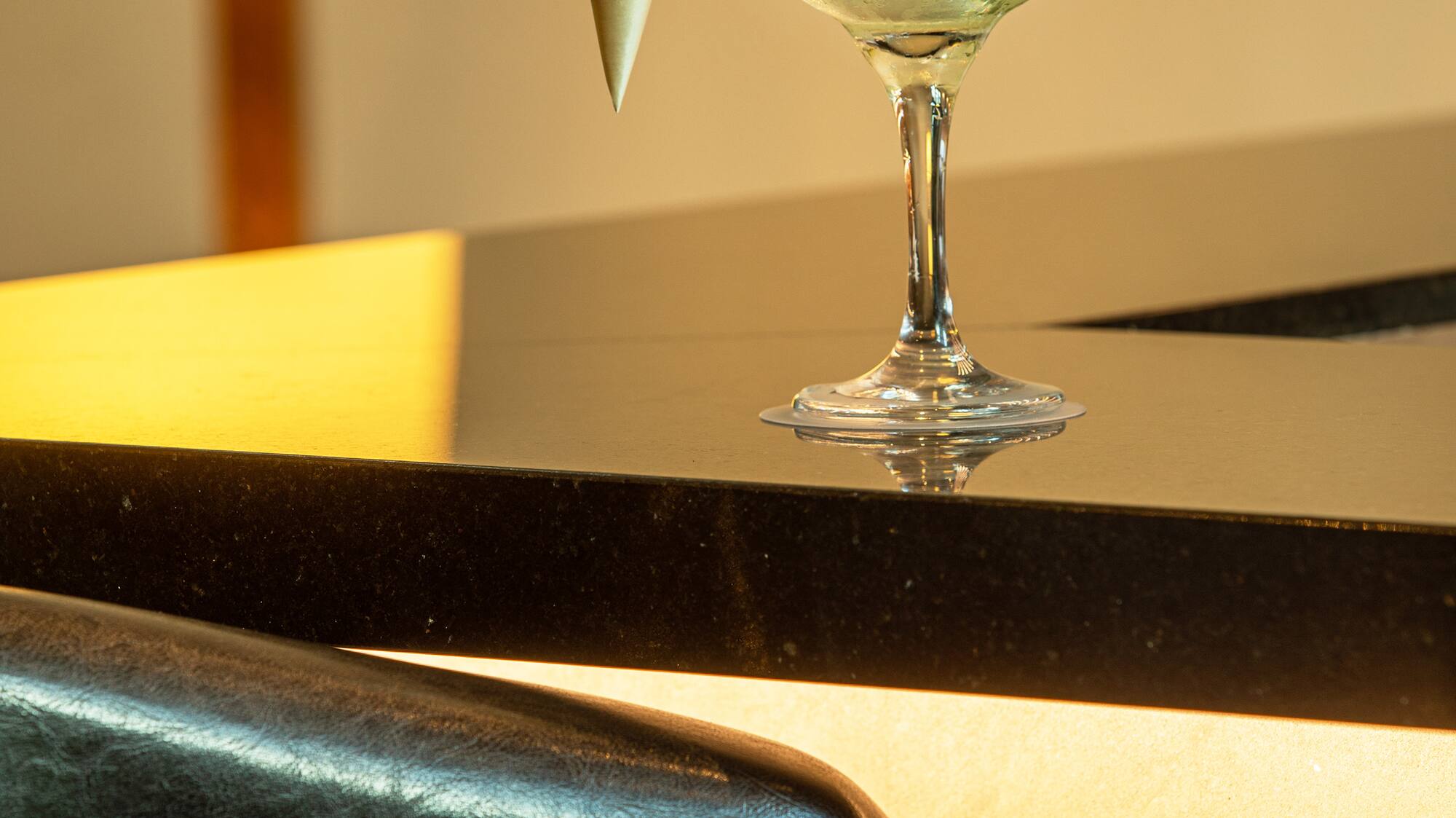 a glass with a drink and a cone on a counter
