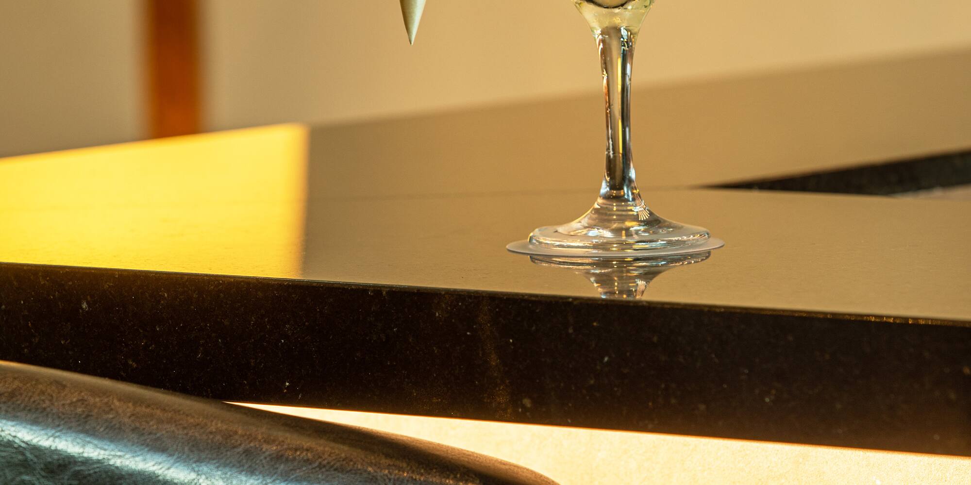a glass with a drink and a cone on a counter