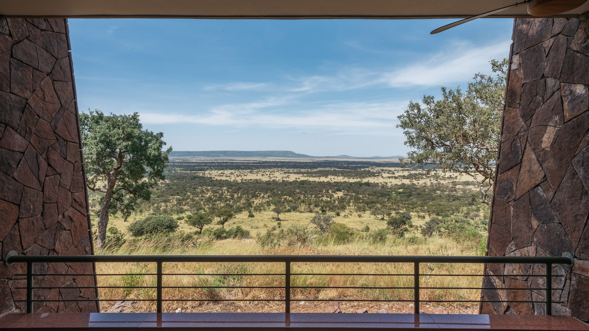 African safari lodge balcony view of vast savanna landscape.