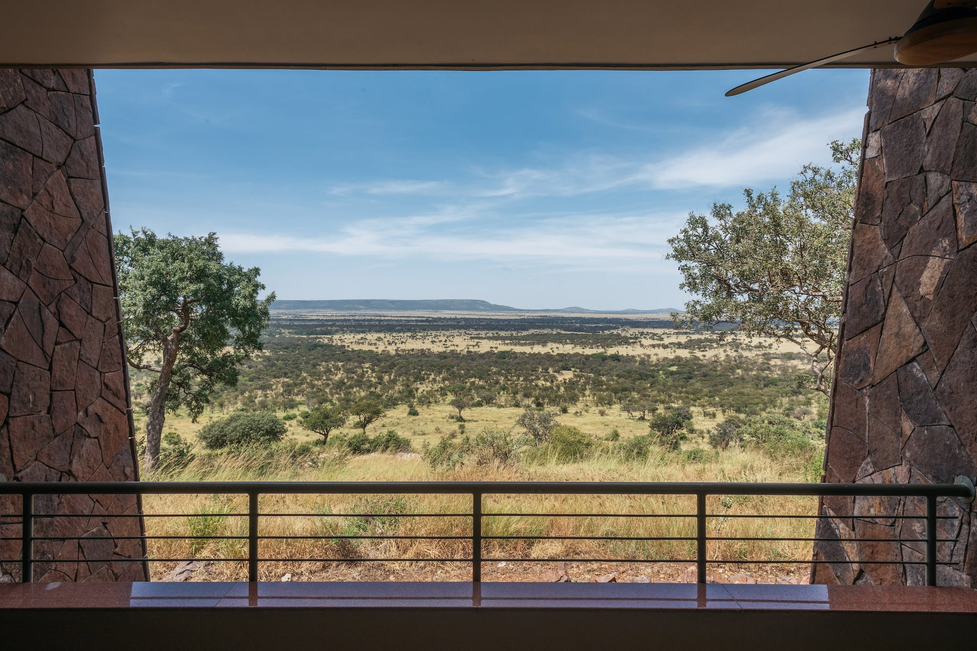 African safari lodge balcony view of vast savanna landscape.