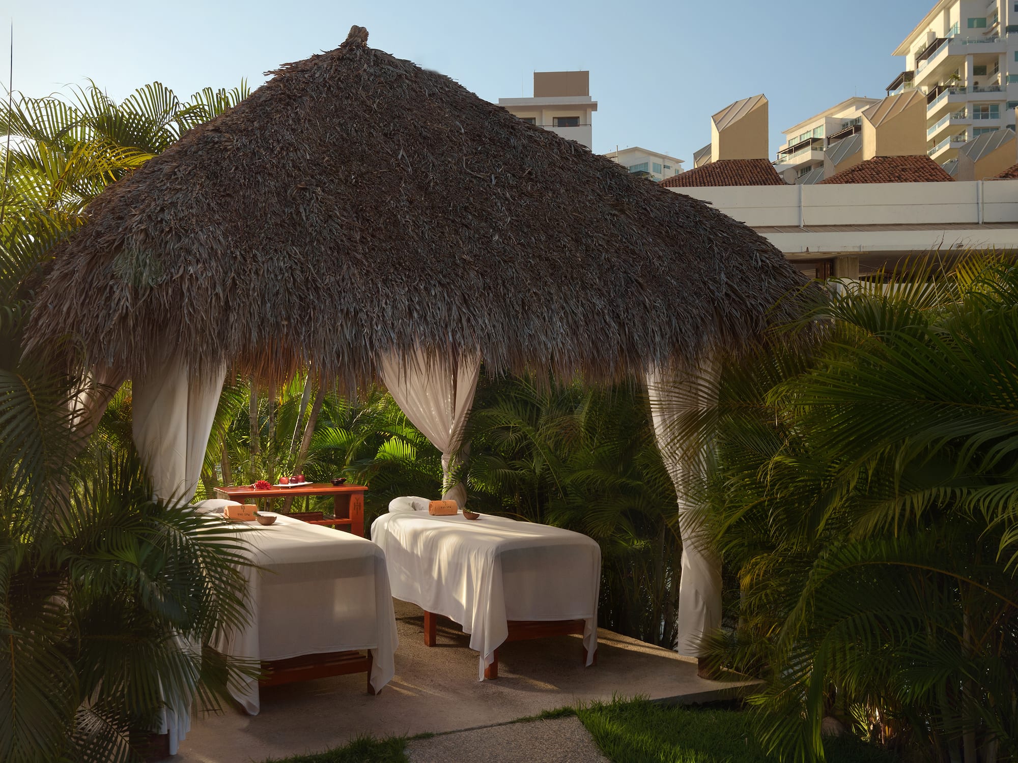 a massage tables under a straw hut