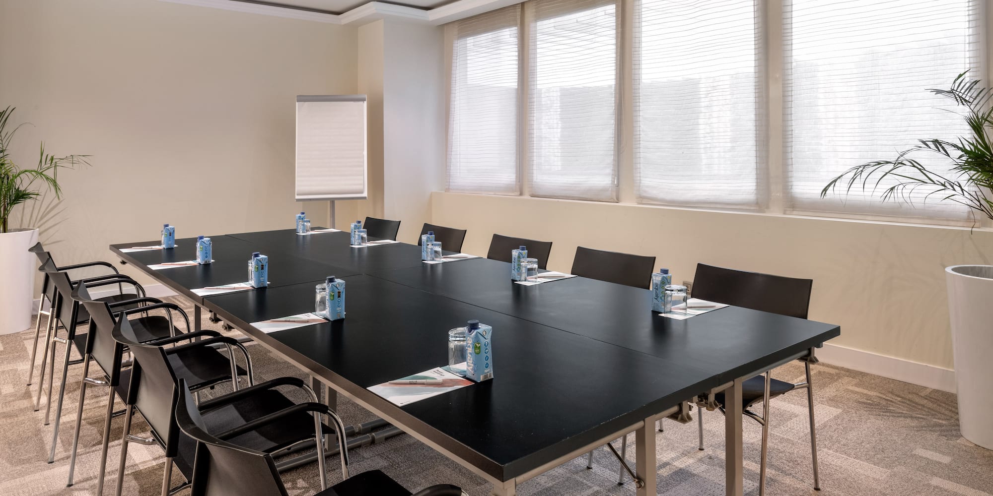 a conference room with a black table and chairs