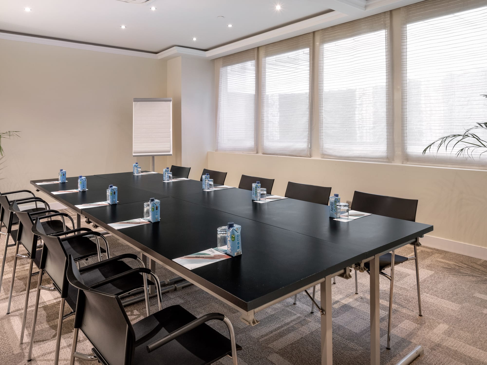a conference room with a black table and chairs