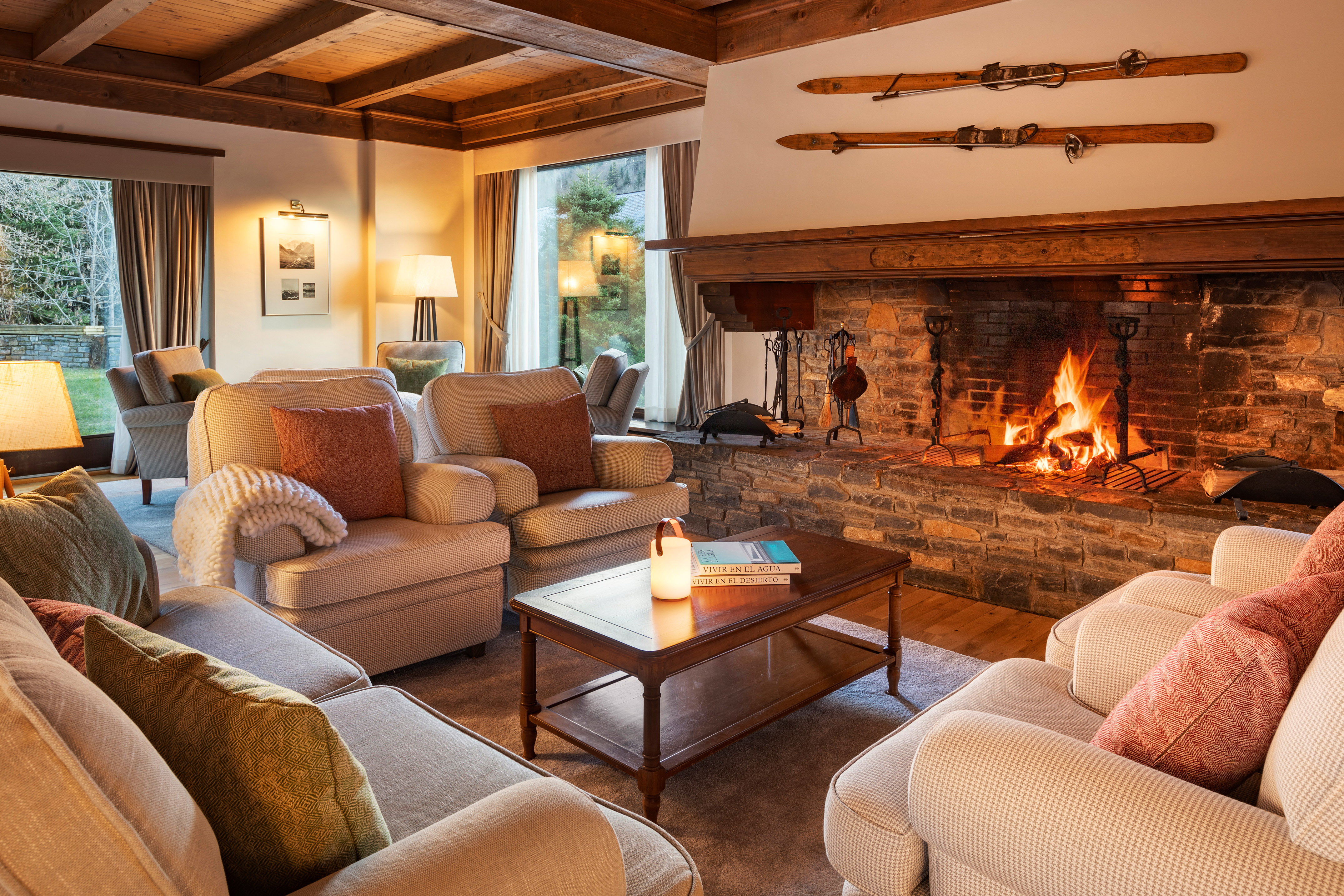 Cozy ski lodge living room with stone fireplace, wooden beams, and comfy sofas.
