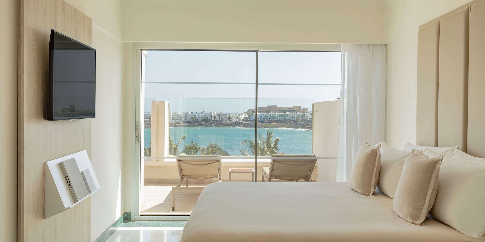 a bedroom with a large glass door and a large window