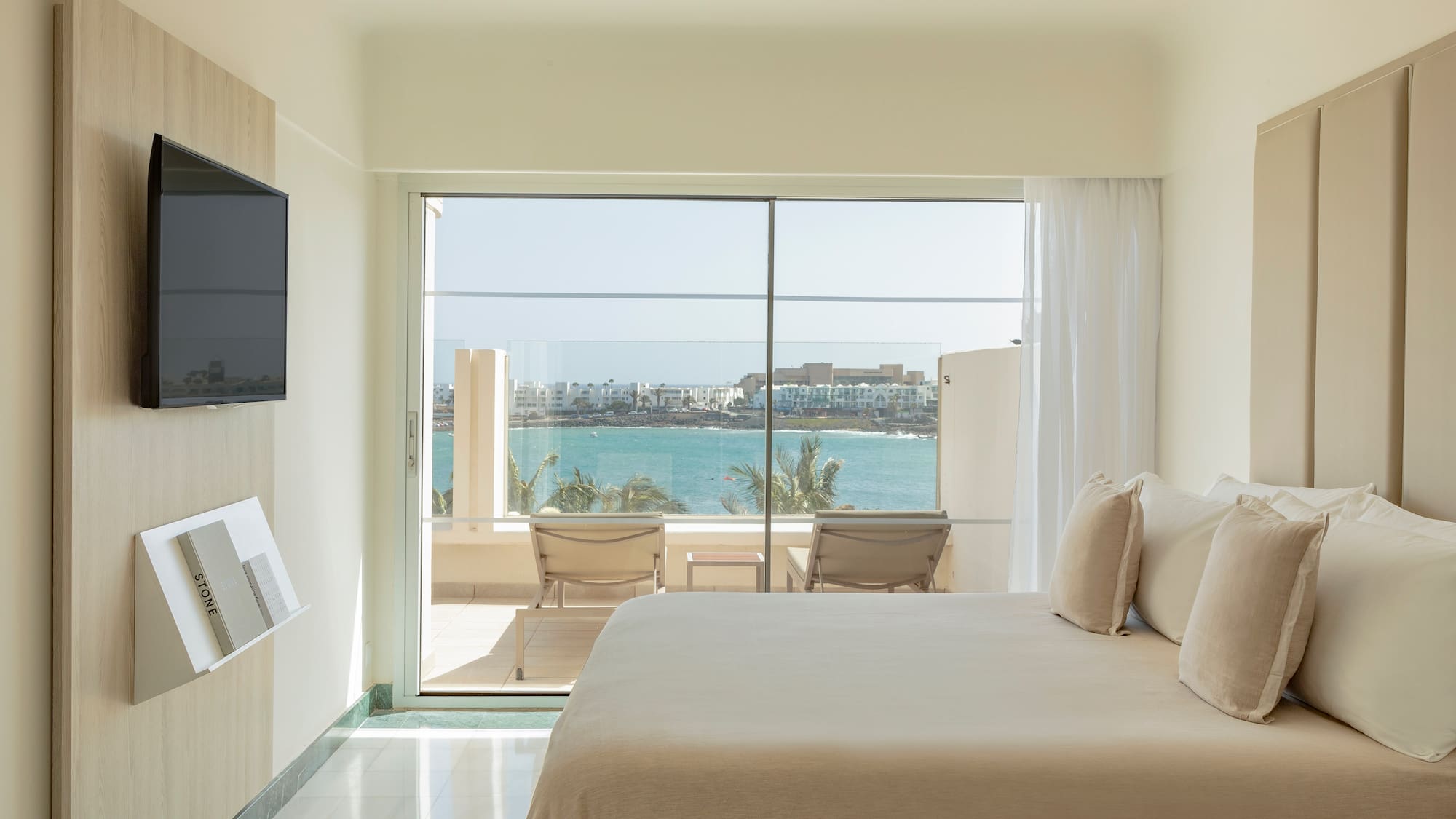 a bedroom with a large glass door and a large window