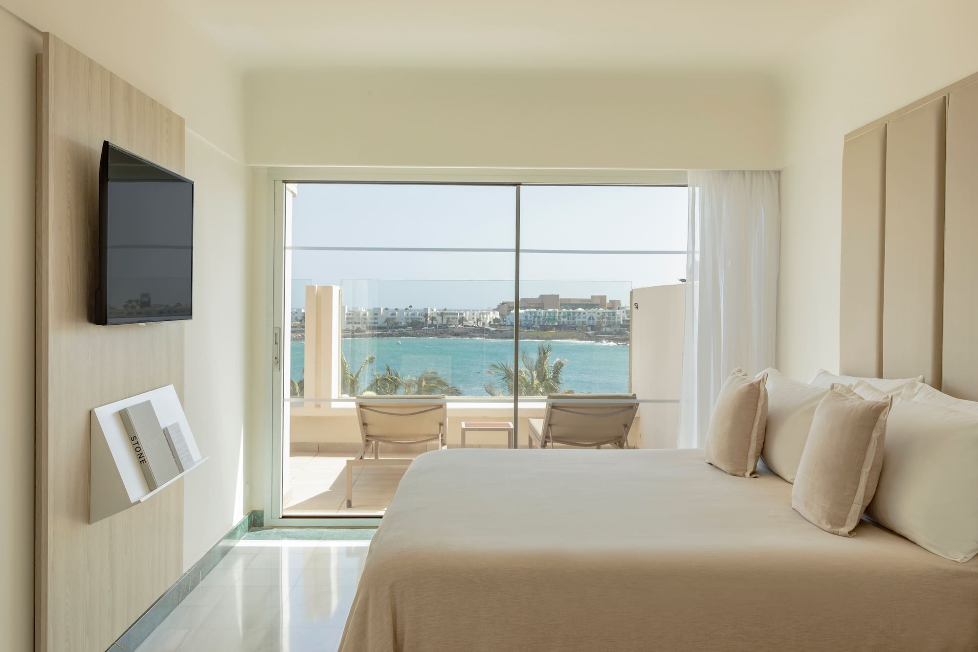 a bedroom with a large glass door and a large window