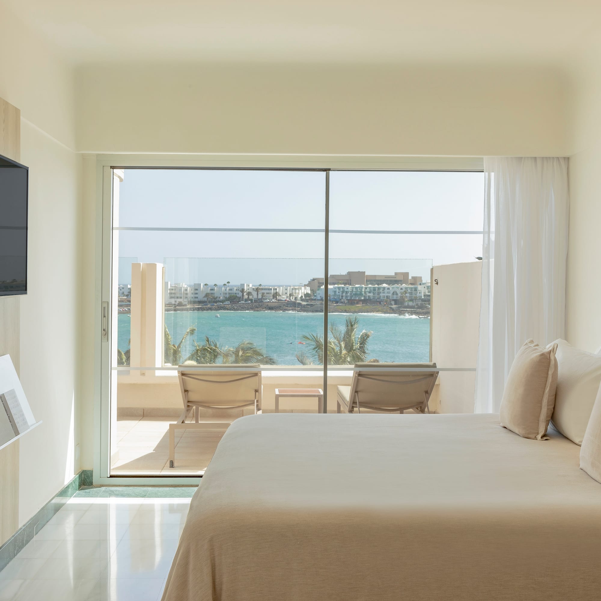 a bedroom with a large glass door and a large window