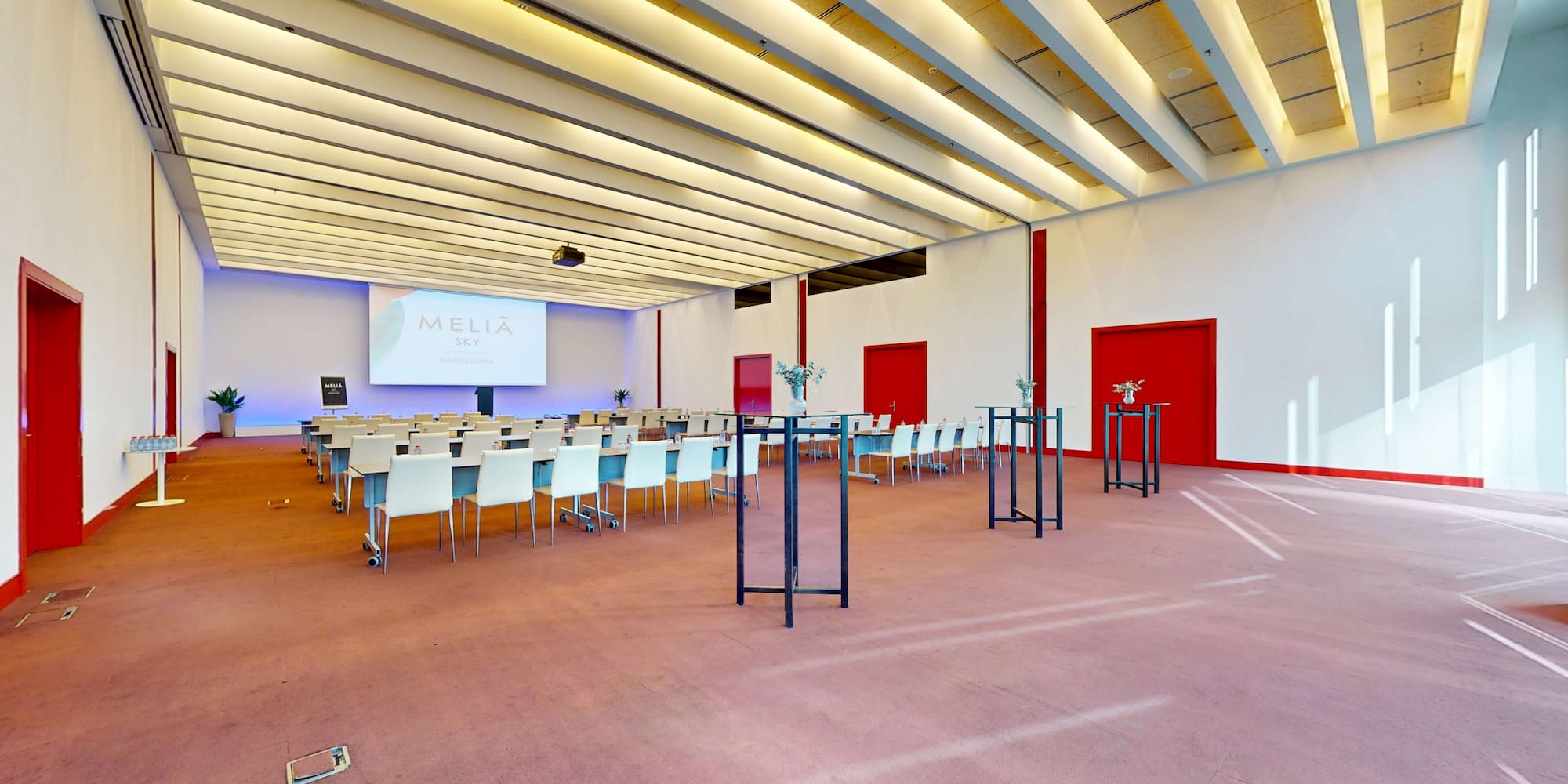 Spacious Meliá Sky Barcelona meeting room with modern setup & projector.