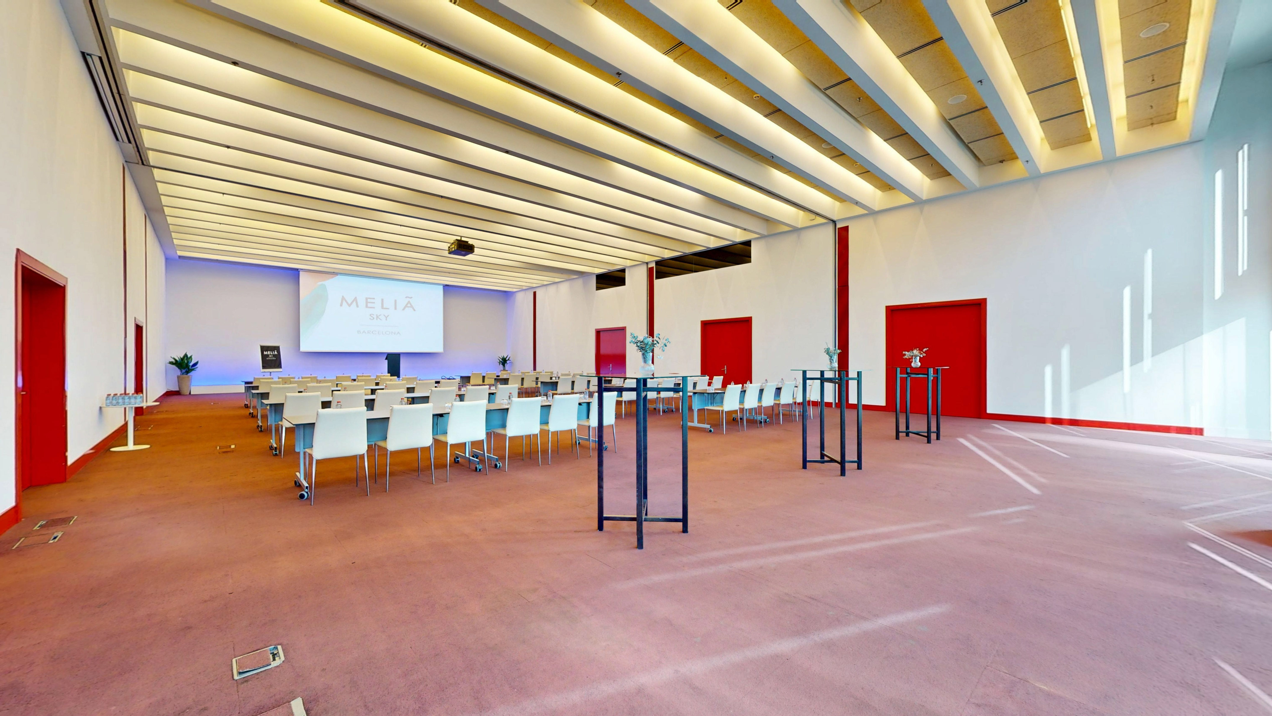 Spacious Meliá Sky Barcelona meeting room with modern setup & projector.