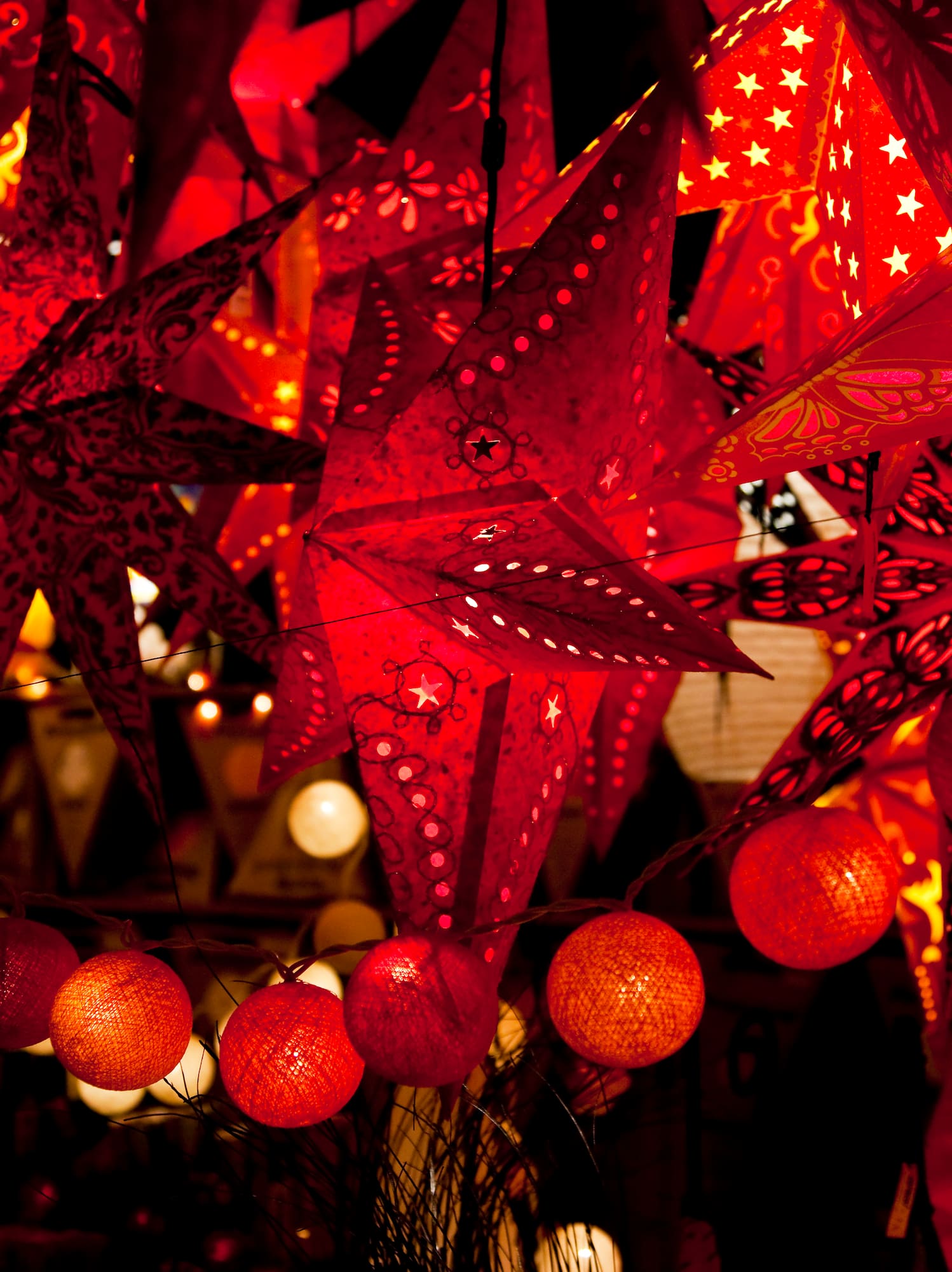 Red star lanterns and spherical string lights, illuminated for festive decoration.