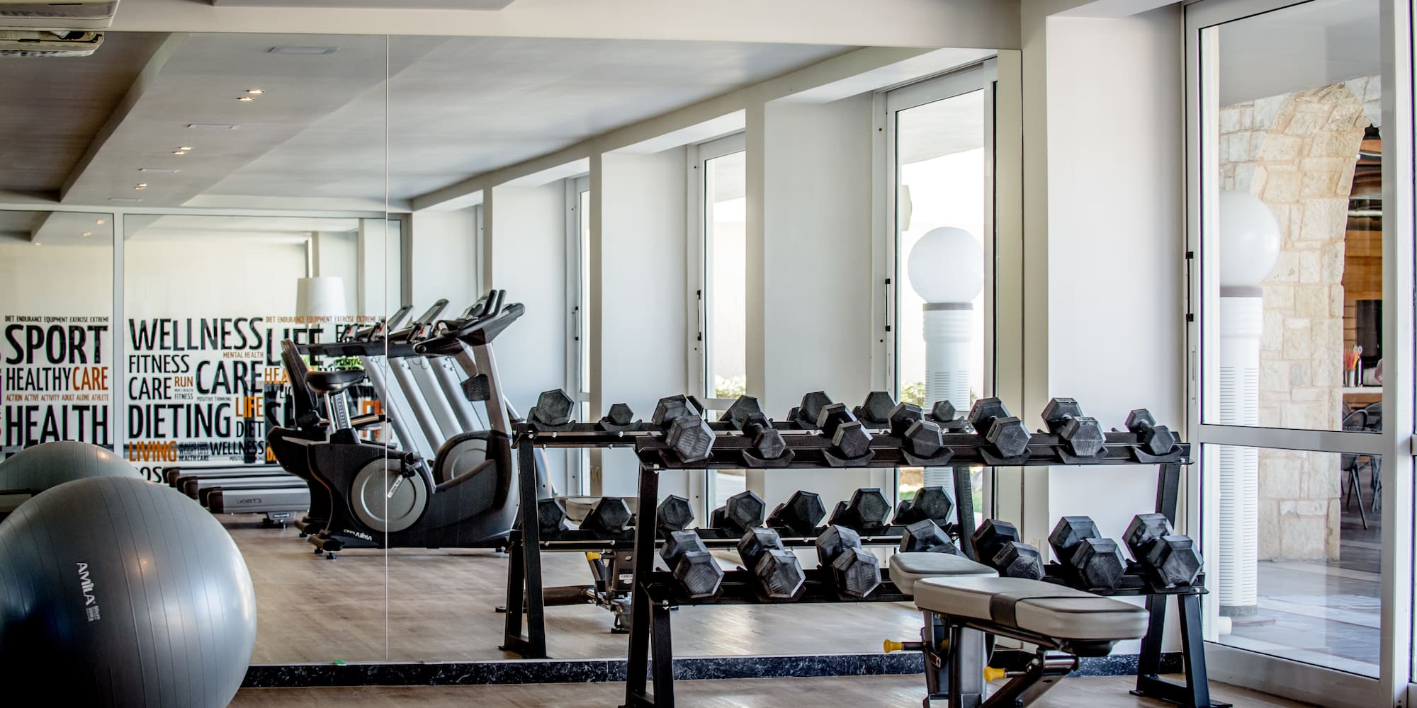 a room with exercise equipment and a large mirror