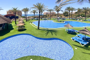 a pool with chairs and umbrellas on grass