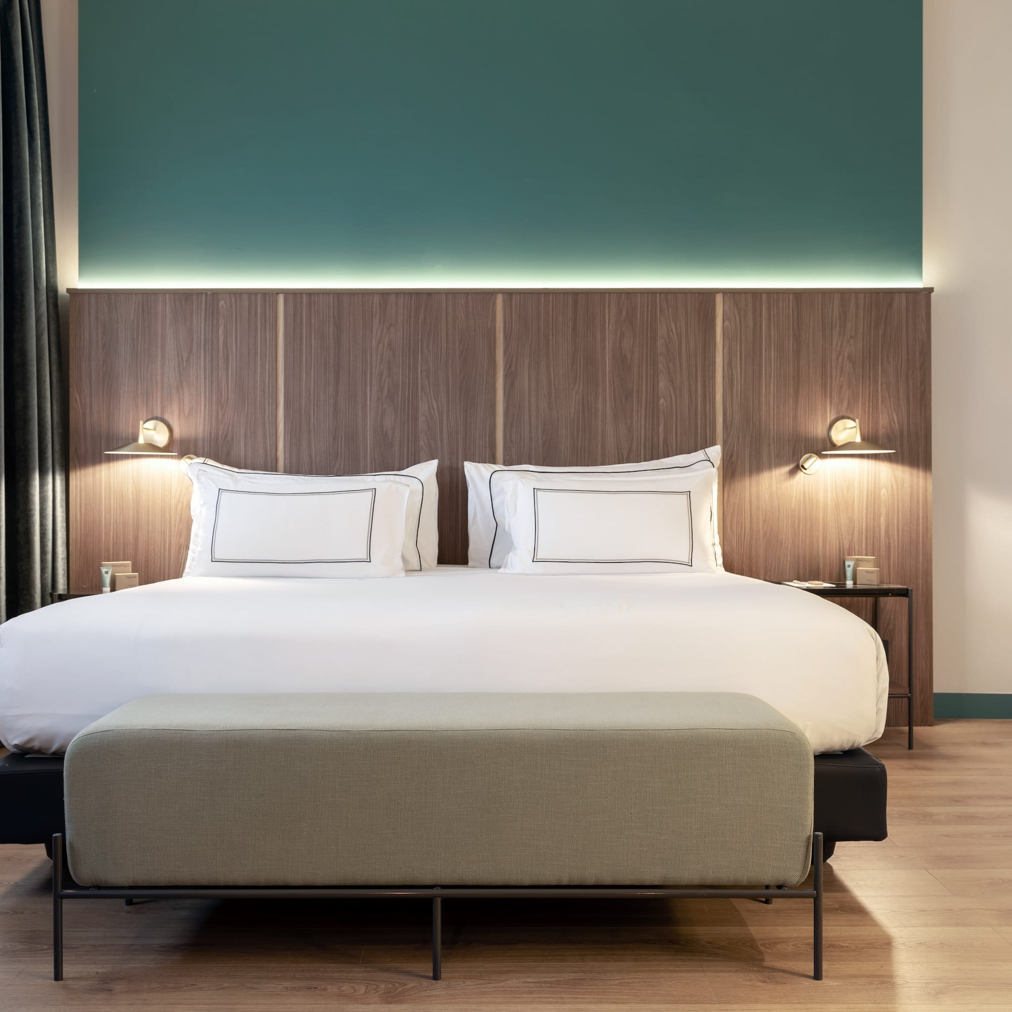 a bed with a bench and lamps