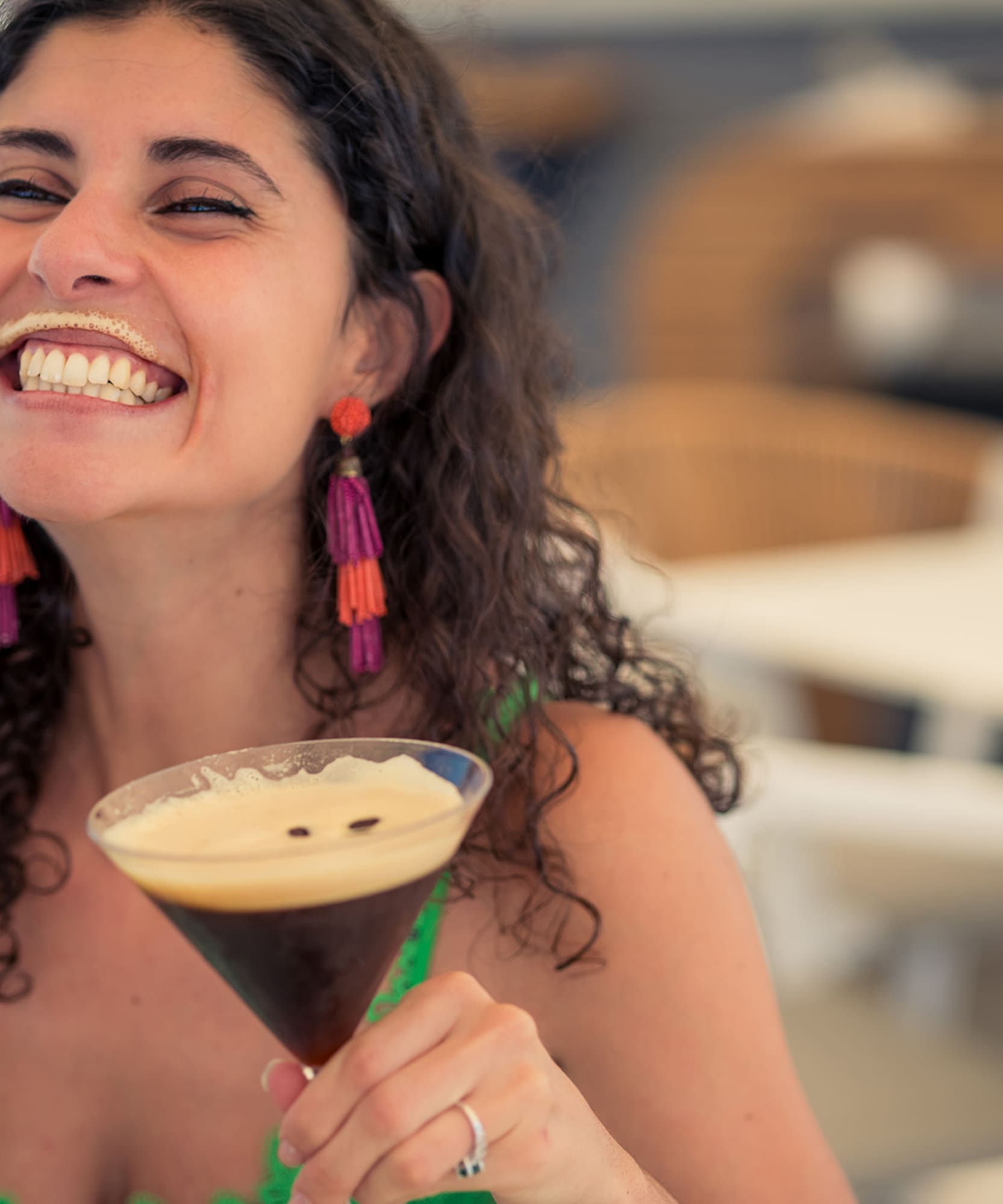 a woman smiling with a drink in her hand
