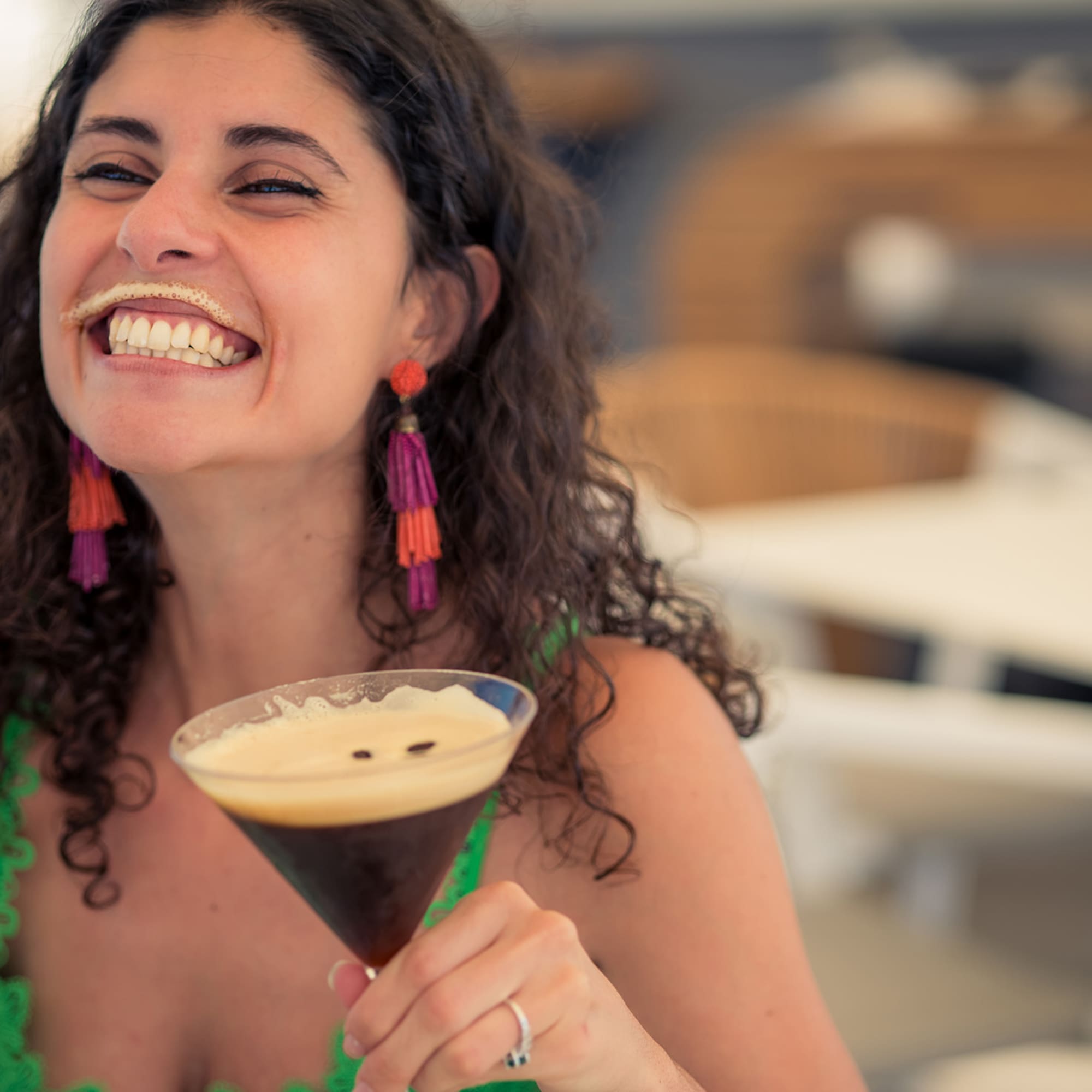 a woman smiling with a drink in her hand