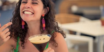 a woman smiling with a drink in her hand