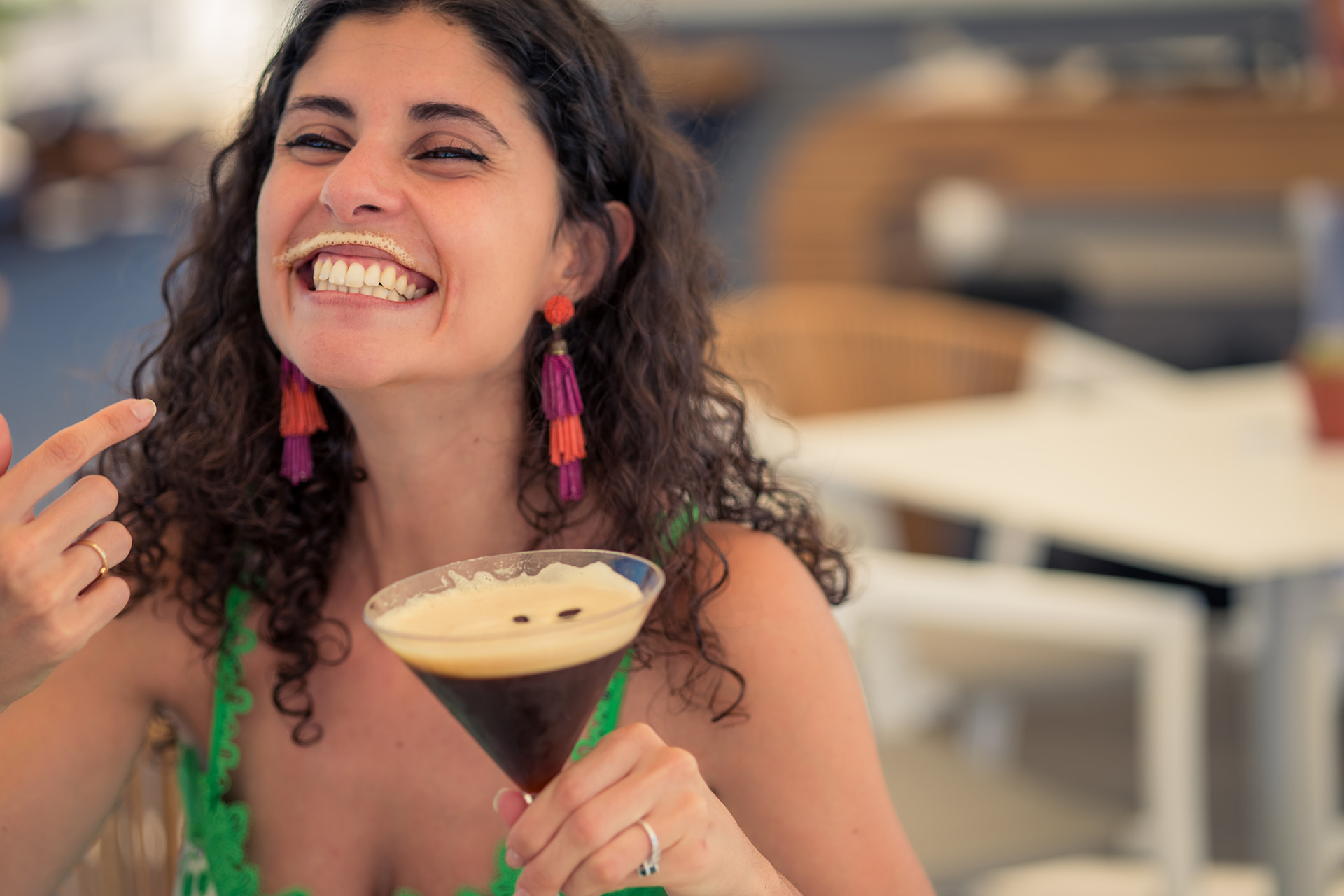 a woman smiling with a drink in her hand