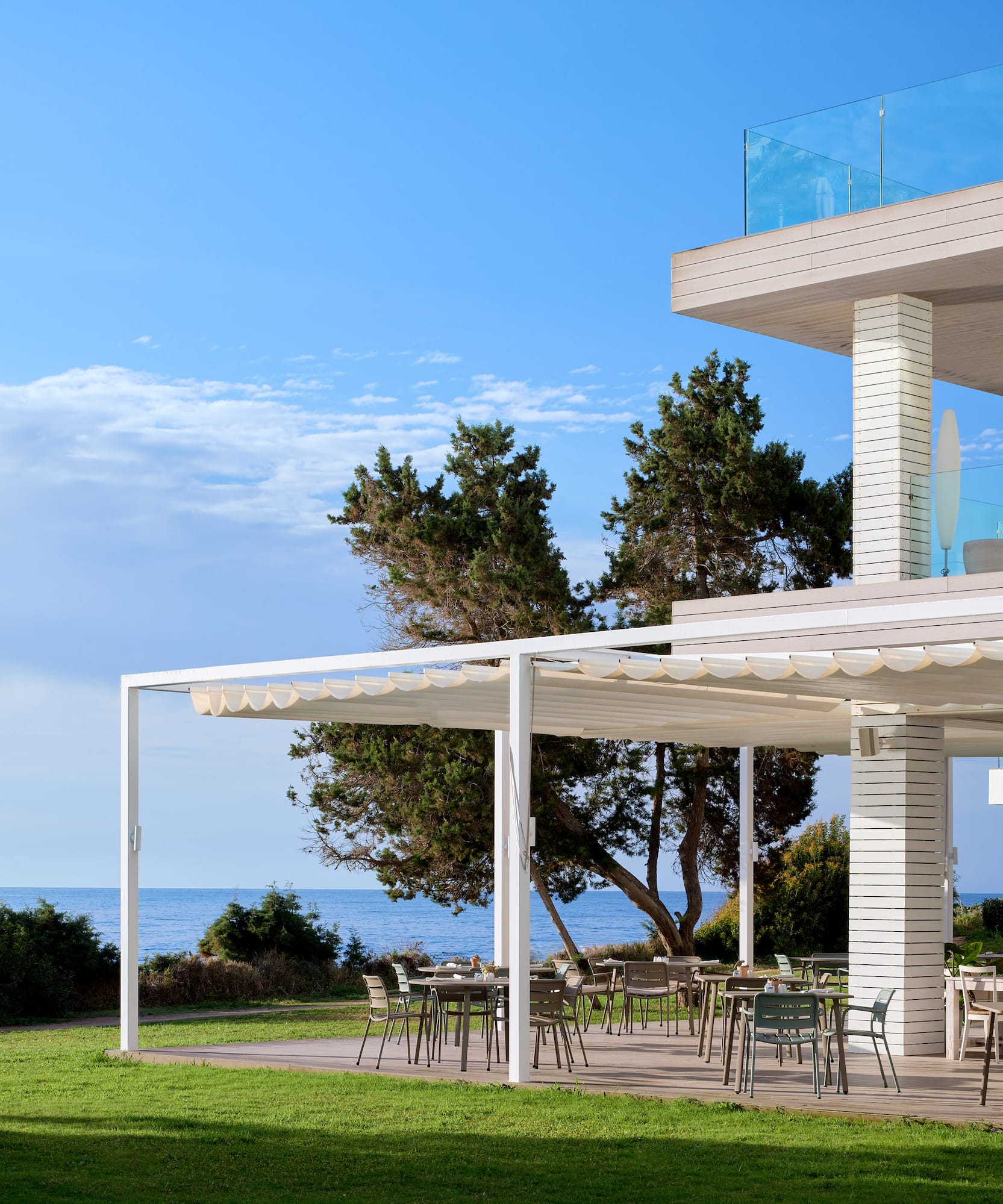 a white house with a lawn and chairs