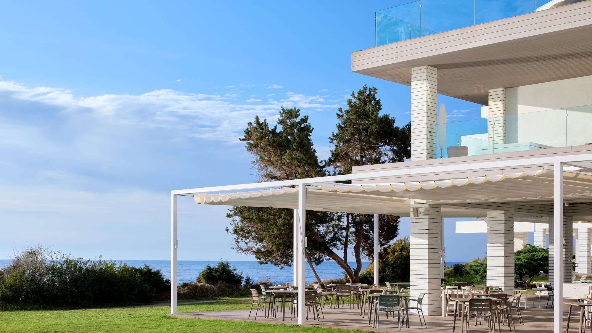 a white house with a lawn and chairs