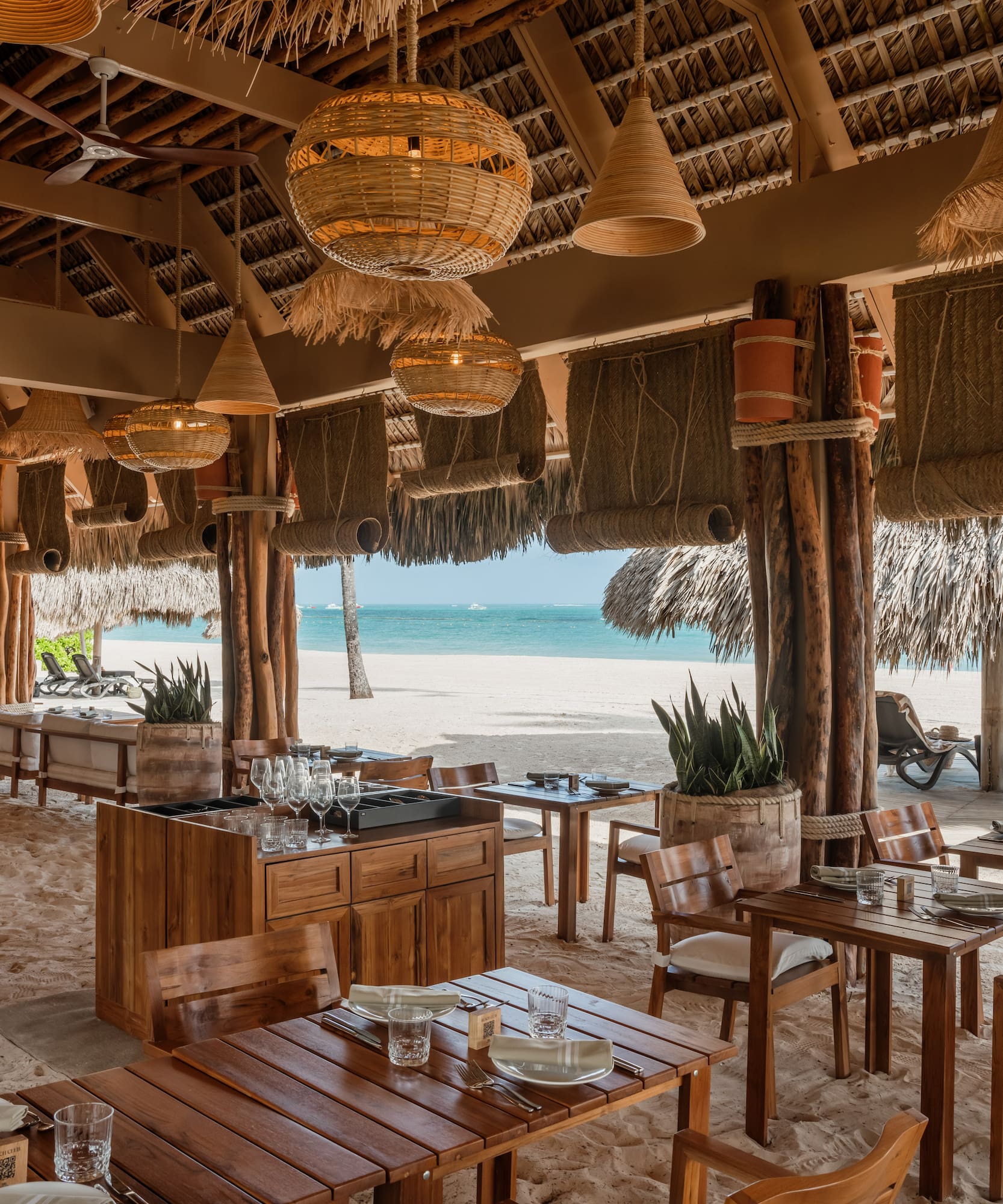 a restaurant with tables and chairs on a beach