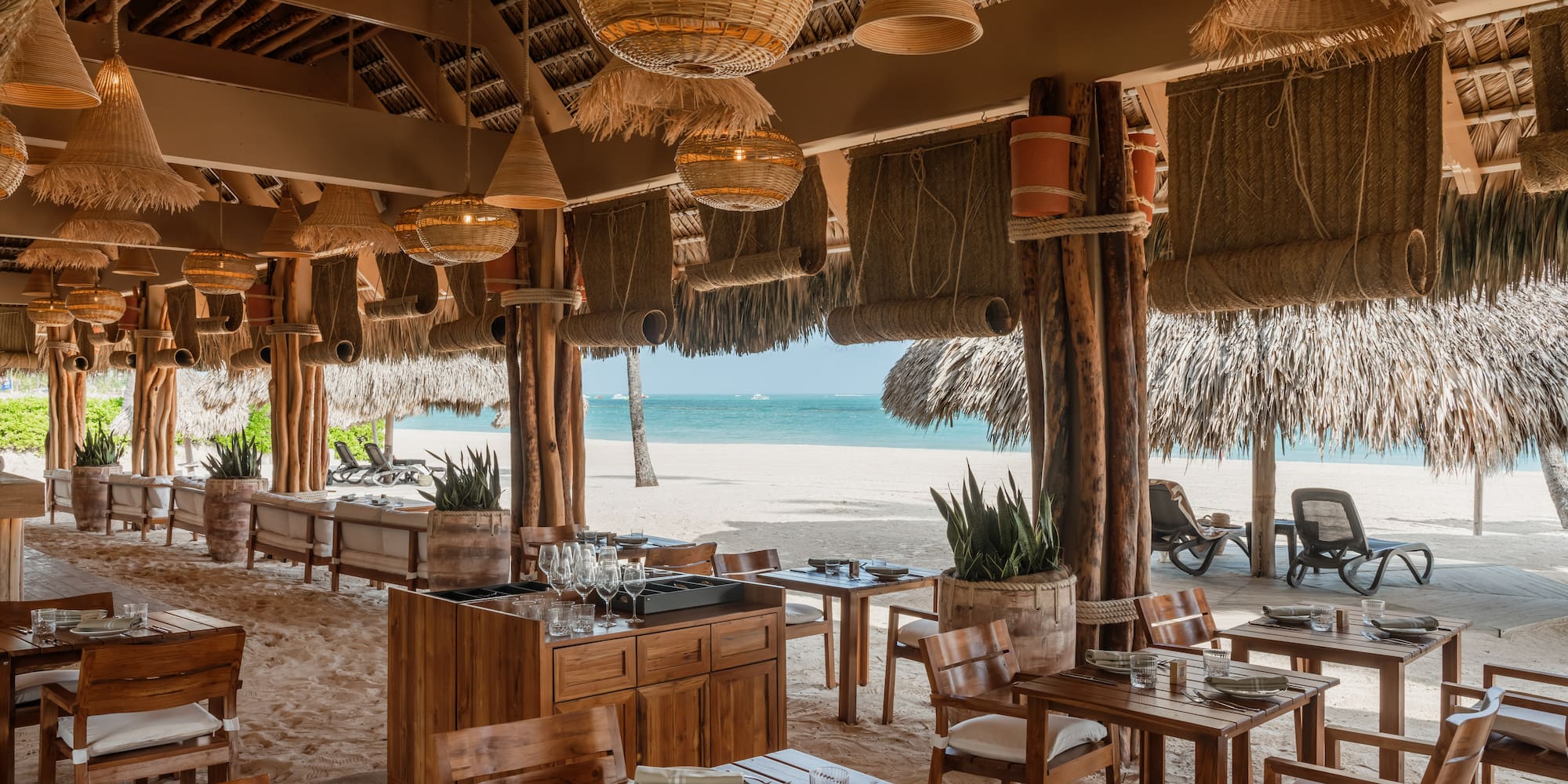 a restaurant with tables and chairs on a beach