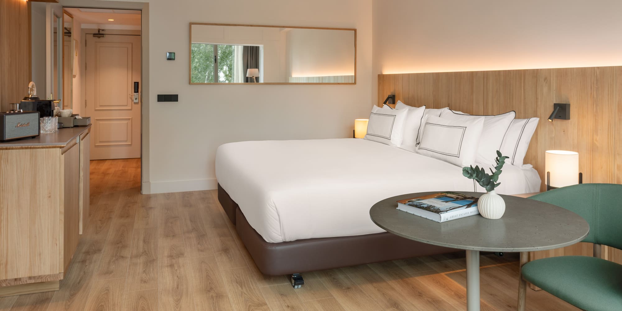 a bed with white sheets and a round table