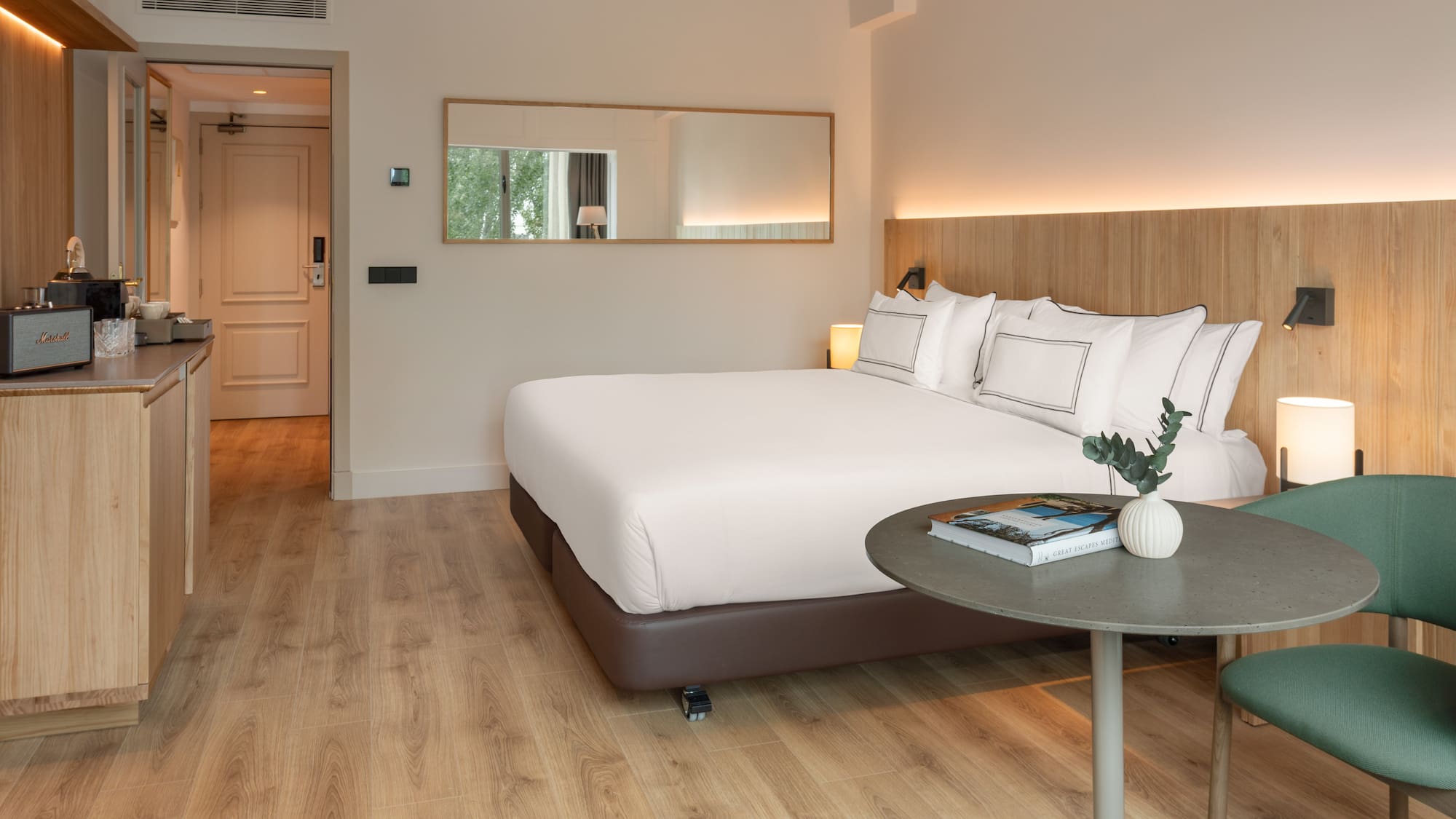 a bed with white sheets and a round table