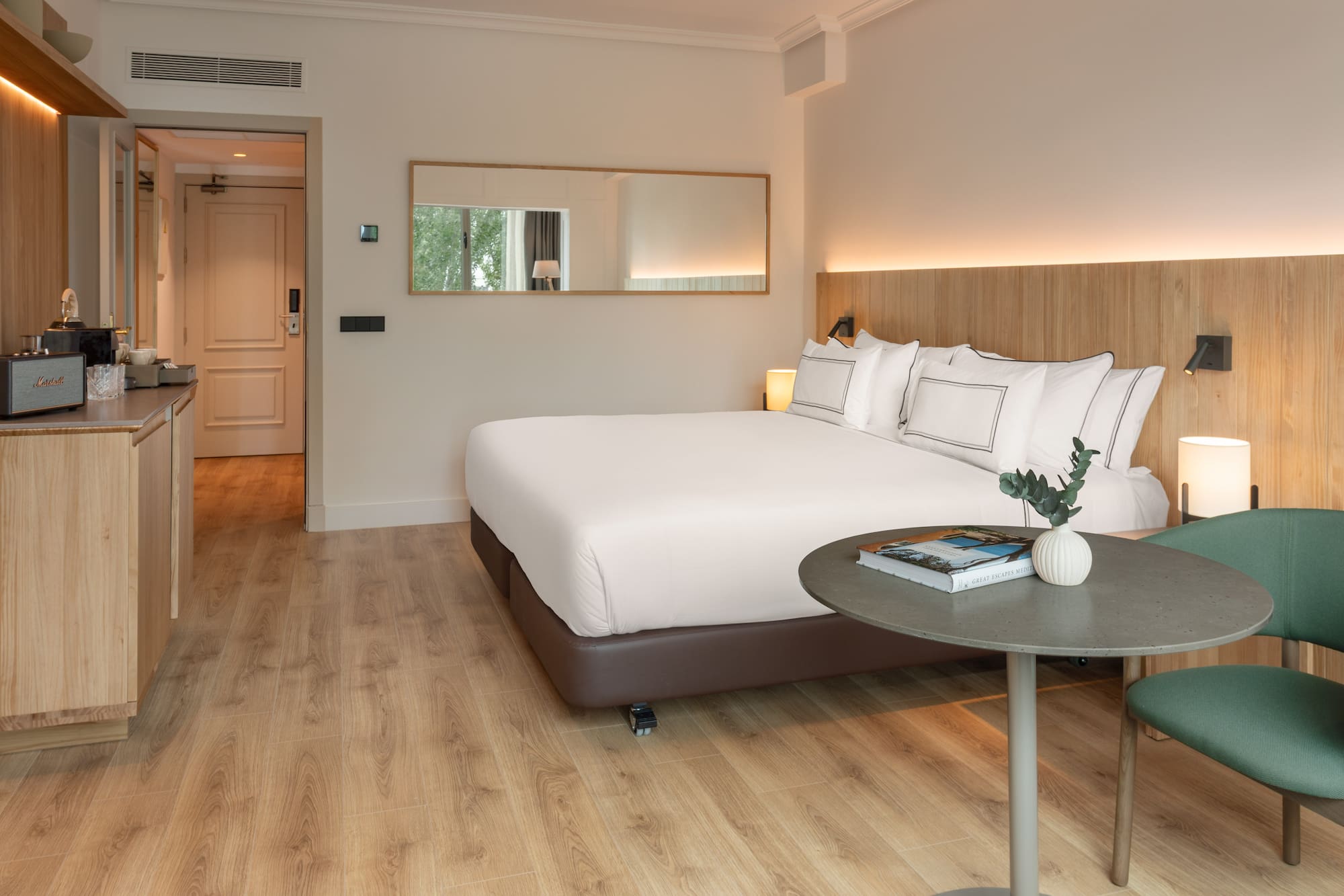 a bed with white sheets and a round table