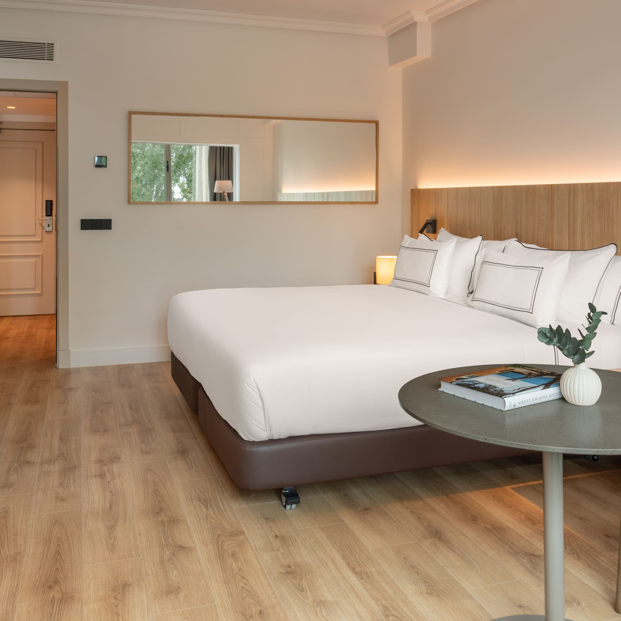 a bed with white sheets and a round table