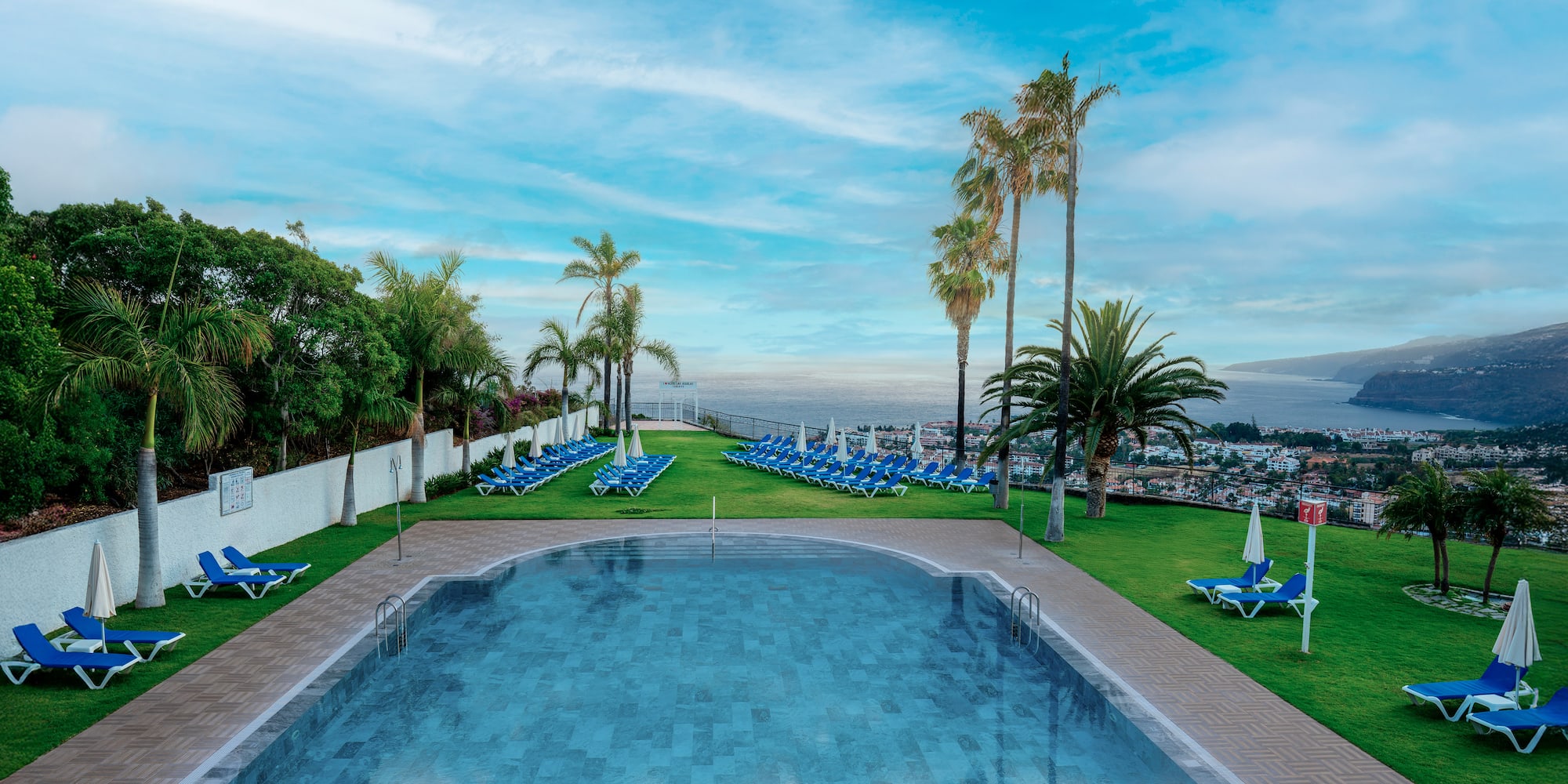 a pool with chairs and trees around it