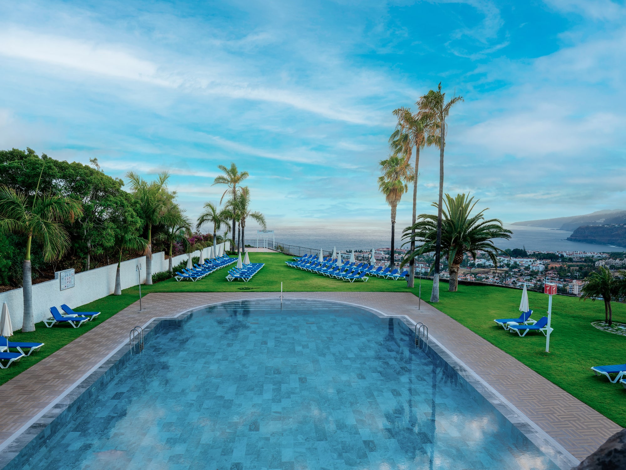 a pool with chairs and trees around it