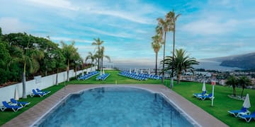 a pool with chairs and trees around it