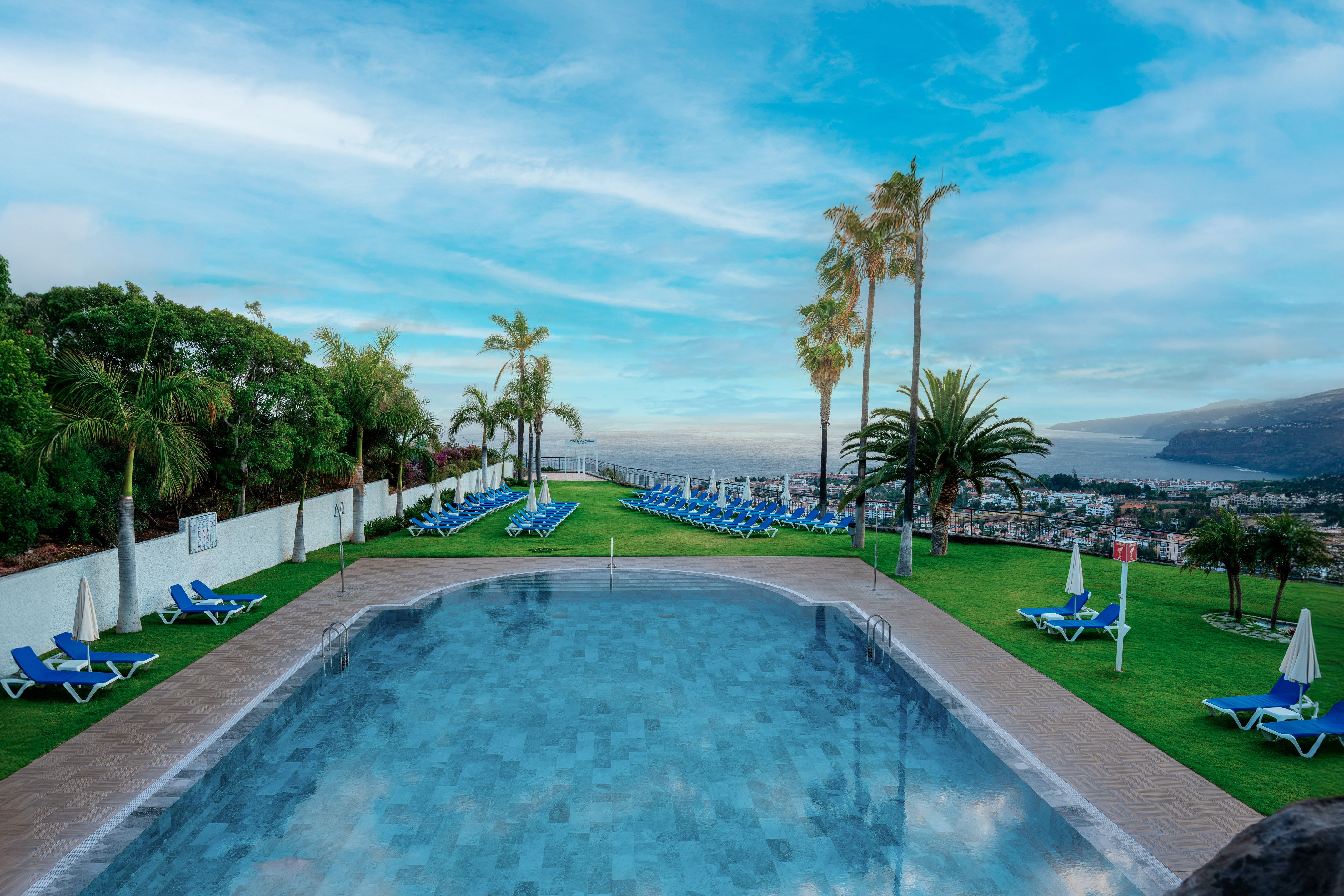 a pool with chairs and trees around it