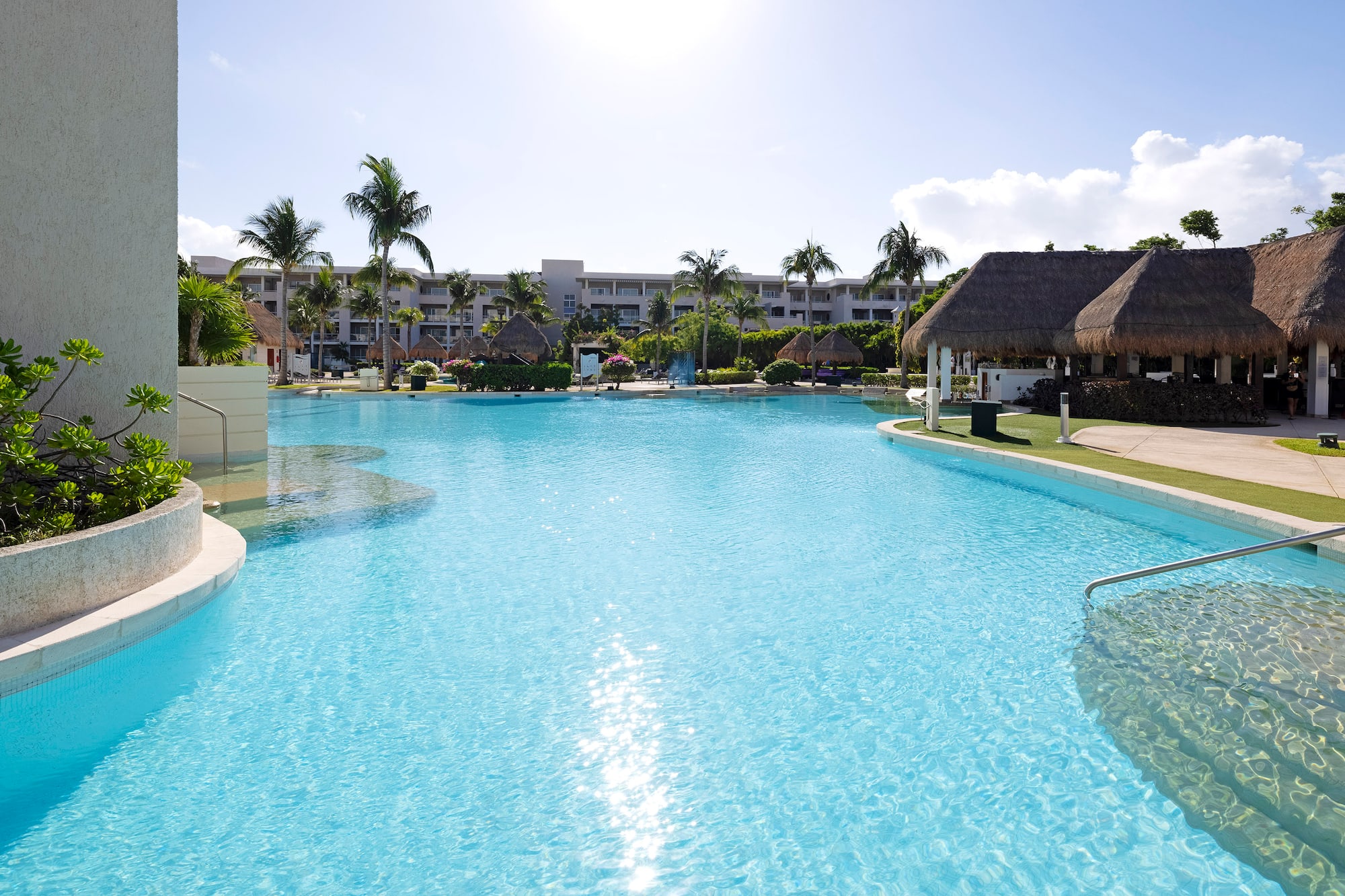 a pool with a building and palm trees