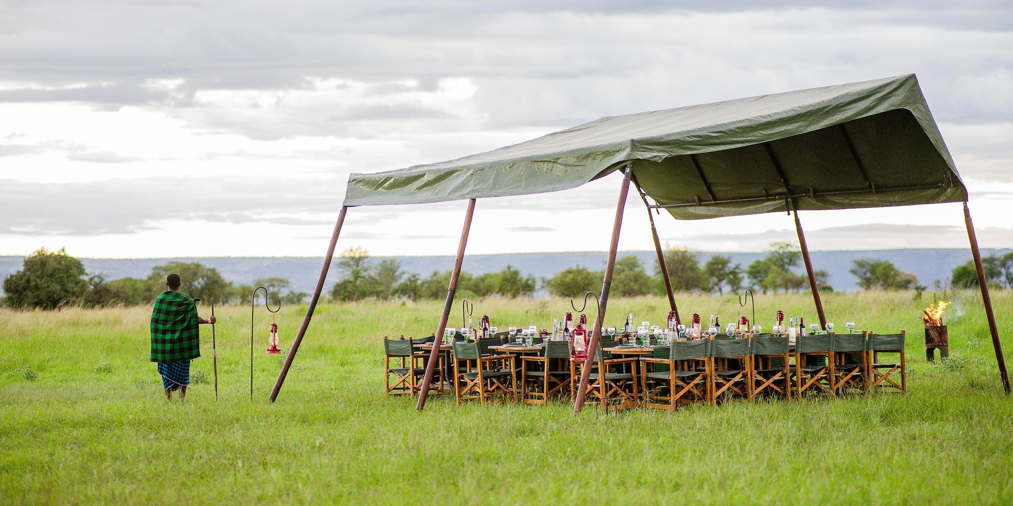 a man standing in a field with a tent