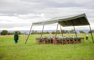 a man standing in a field with a tent