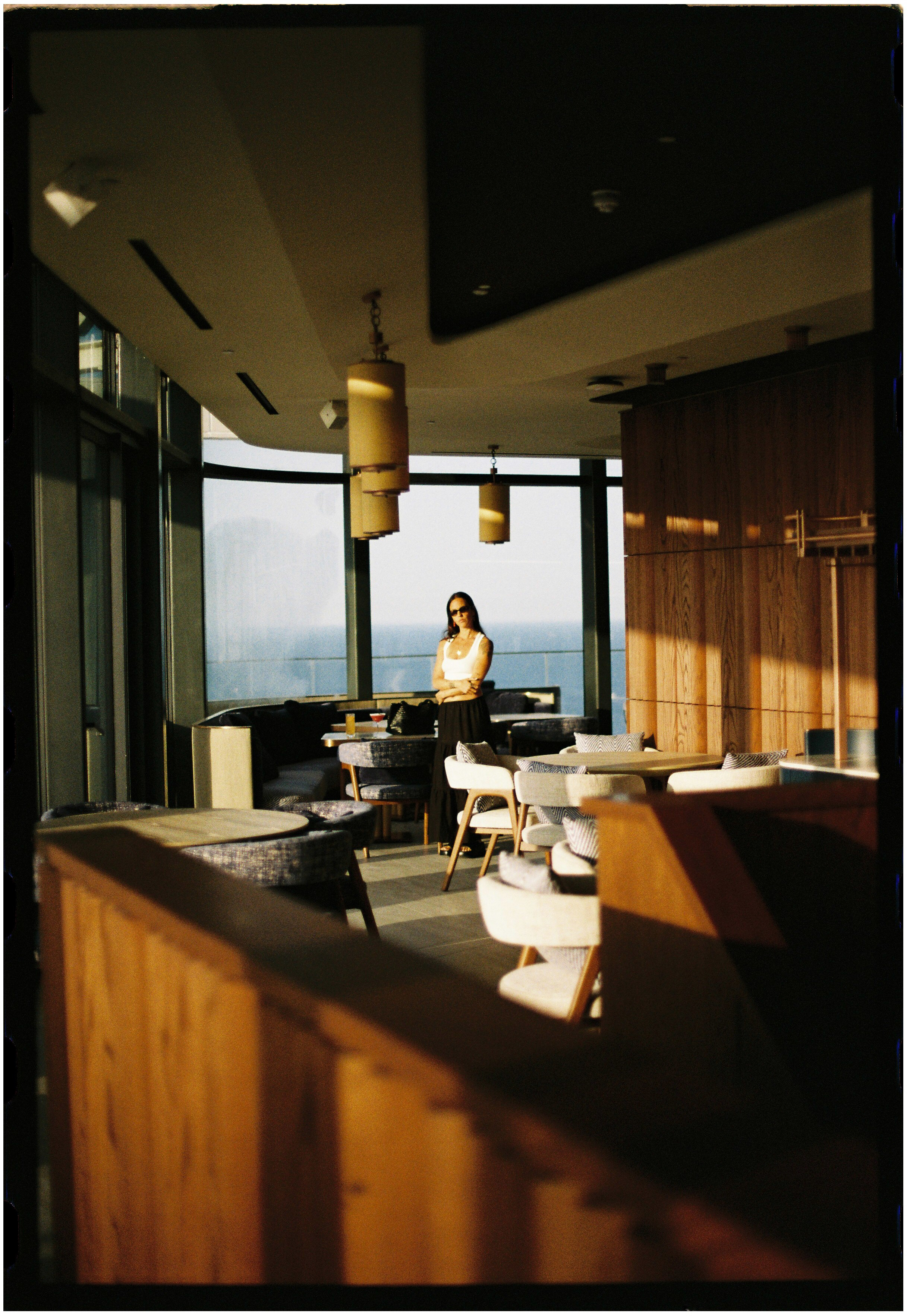a woman standing in a room with chairs and tables