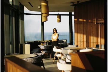 a woman standing in a room with chairs and tables